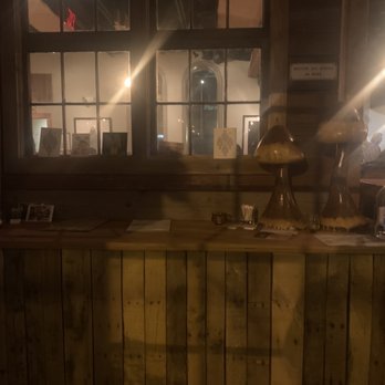 Morel - a view of a restaurant counter with a light shining through the window - New American Near Me - Milwaukee, Wisconsin