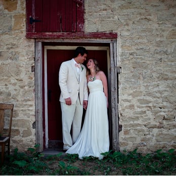 Over The Vines - a bride and groom in front of a stone building - Venues & Event Spaces Near Me - Edgerton, Wisconsin