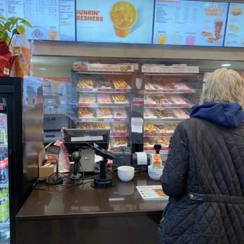 Dunkin' -  a woman standing at a counter in a donut shop - Donuts Near Me - Harrison, New York