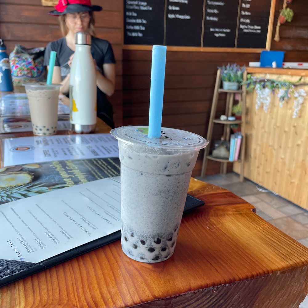 black sesame Milk Tea with boba, and my partner's Lavender Milk Tea in the background black sesame Milk Tea with boba, and my partner's Lavender Milk Tea in the background