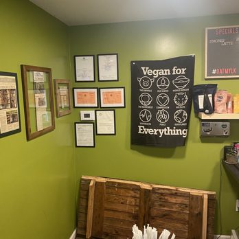 The Vegan Grocery Store - a green wall with posters on it - Grocery Near Me - North Tonawanda, New York