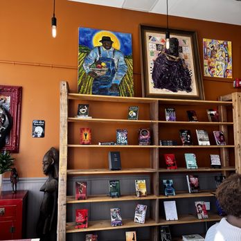Rofhiwa Book Café - a man sitting in front of a bookshelf - Bookstores Near Me - Durham, North Carolina Rofhiwa Book Café - a man sitting in front of a bookshelf - Bookstores Near Me - Durham, North Carolina