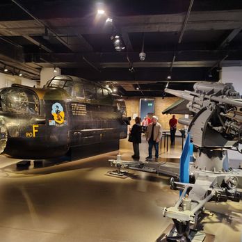Imperial War Museum - front end of WW2 Avro Lancaster British heavy bomber, with German 88 mm anti tank anti aircraft gun  adjacent - Museums Near Me - London, XGL