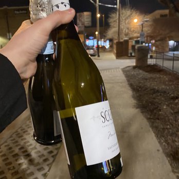 Village Wine and Spirits - a hand holding two bottles of wine - Beer, Wine & Spirits Near Me - Nashville, Tennessee