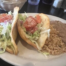 Two tacos with refried beans and rice. The crispiness of the fried flour, tortilla shell, Parm cheese really complement the flavor!