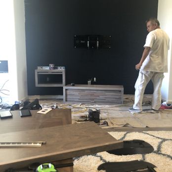 Jennifer Davis Painting - Wooden wall mount entertainment center being assembled. - Painters Near Me