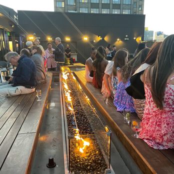 RoofTop at the Exchange Place - lots of people sit by the firepit - New American Near Me - Jersey City, New Jersey RoofTop at the Exchange Place - lots of people sit by the firepit - New American Near Me - Jersey City, New Jersey