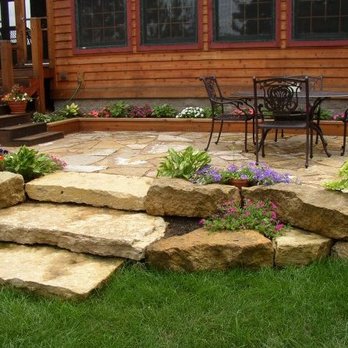 Environmental Landscape Management - a patio with a table and chairs - Landscaping Near Me - Hudson, Wisconsin Environmental Landscape Management - a patio with a table and chairs - Landscaping Near Me - Hudson, Wisconsin