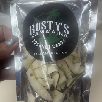 Rusty's Kama'aina Coconut Candy - a hand holding a bag of bananas - Specialty Food Near Me