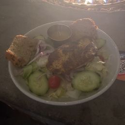 House salad with salmon and a yellow dressing.