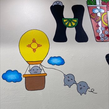 Hi Boba - New Mexico Boba - Decorative cartoon wall art showing a hot air balloon with a smiling cloud inside, connected to a string of clouds, with other colorful illustrations nearby. - Coffee & Tea Near Me - Rio Rancho, New Mexico