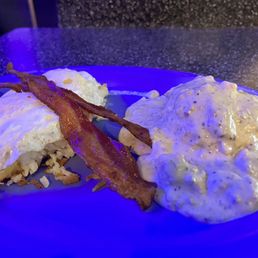 The Grant "The Perfect Breakfast" containing biscuits and gravy with slices of bacon and eggs over easy over hash browns