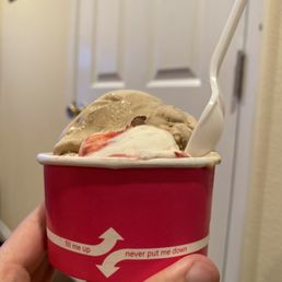 a hand holding a cup of ice cream a hand holding a cup of ice cream