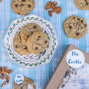 The Cookie - a plate of chocolate chip cookies and a box of pecans - Desserts Near Me The Cookie - a plate of chocolate chip cookies and a box of pecans - Desserts Near Me