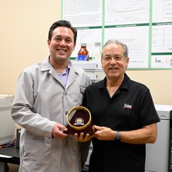 David Smith Law Firm - David Smith (L) and Dr. Lee Polite (R) at Axion Labs holding the ACS-CHAL Forensic Lawyer-Scientist golden column award.