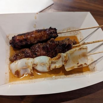 Zaab Burger - skewered meat on a white plate - Thai Near Me - New York, New York Zaab Burger - skewered meat on a white plate - Thai Near Me - New York, New York