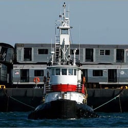 On Scene Marine Service - tug towing old long  .  island rail road cars to reef off marches.