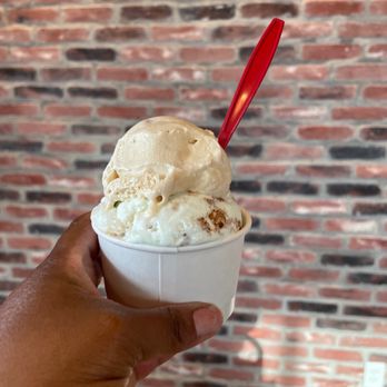 Moo La La - a hand holding a cup of ice cream - Desserts Near Me - Miramar Beach, Florida