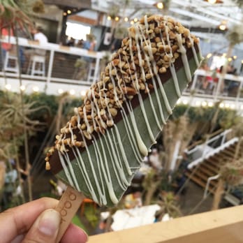 Popbar - Pistachio Pop dipped in Dark Chocolate with Crushed Hazelnuts and White Chocolate Drizzle - Desserts Near Me - Anaheim, California Popbar - Pistachio Pop dipped in Dark Chocolate with Crushed Hazelnuts and White Chocolate Drizzle - Desserts Near Me - Anaheim, California