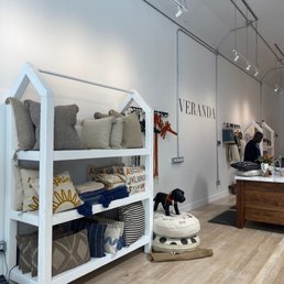 Showcase of pillows, textiles, and pet accessories inside Veranda store in Oakland, CA, with a person browsing in the background.