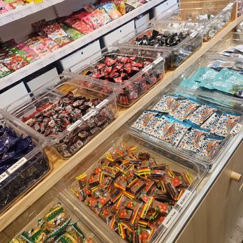 Snack Oasis - A variety of Japanese candies are arranged in clear plastic containers on a store shelf, with colorful packaging and different flavors. - Convenience Stores Near Me - Chicago, Illinois