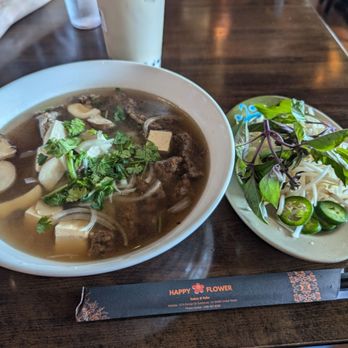 Happy Flower Eatery & Boba - Pho noodle soup with Beyond Beef, it has yummy broth and flat rice noodles! (And jasmine milk tea with boba in the background.) - Vietnamese Near Me - Sunnyvale, California