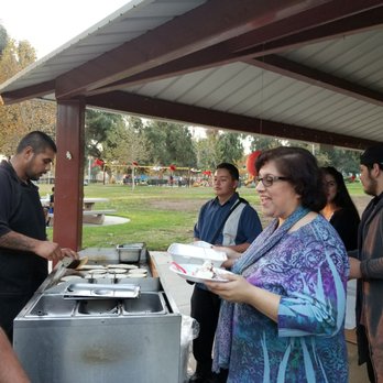Estos Tacos - a group of people standing around a table - Caterers Near Me