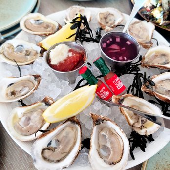 Driftwood Kitchen - A dozen of oysters with cute mini Tabasco bottles :) - Seafood Near Me - Laguna Beach, California