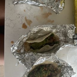 three burritos wrapped in foil three burritos wrapped in foil