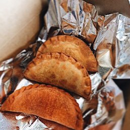 three empanadas wrapped in aluminum foil three empanadas wrapped in aluminum foil