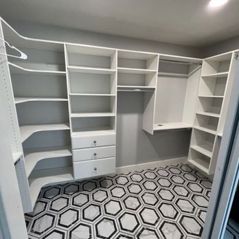 Cova Construction - Master closet - A walk-in closet features white built-in shelves, drawers, and hanging rods, with geometric patterned tile flooring. - General Contractors Near Me - Corona, California