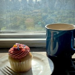 a cup of coffee and a cupcake a cup of coffee and a cupcake