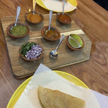 Mestiza - Complimentary appetizer (potato taco) with taco accoutrements (salsas, limes, cilantro, red onion) - Mexican Near Me - St. Louis, Missouri Mestiza - Complimentary appetizer (potato taco) with taco accoutrements (salsas, limes, cilantro, red onion) - Mexican Near Me - St. Louis, Missouri