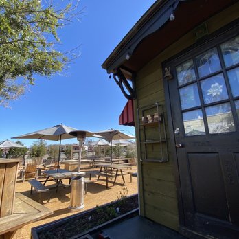 1880 Ice House - The outdoor seating & tables with band stage in the background. - Bars Near Me - Denison, Texas