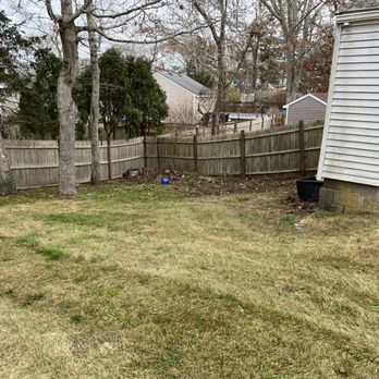 Integrity First Landscaping - a back yard with a fence and a trash can - Landscaping Near Me