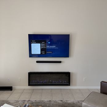 Hang it by Dutch - Completed setup with mounted TV, soundbar, and slimline electric fireplace with concealed cables - TV Mounting Near Me - Ocala, Florida