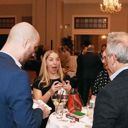 During a reception, a woman has a shocked look on her face after Jesse does magic/mentalism.