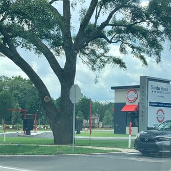 Scooter's Coffee - a parking lot and a tree - Coffee & Tea Near Me - Pace, Florida
