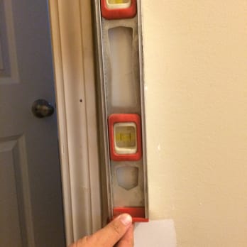 Flagship Construction - a hand holding a level in front of a door - General Contractors Near Me - Myrtle Beach, South Carolina