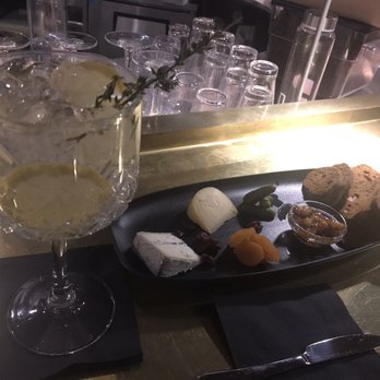 Bar les Cousins - a plate of cheese, crackers, and a glass of wine - Cocktail Bars Near Me - Brossard, Quebec