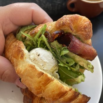 The Sparrow Bakery - Close up of the egg bacon croissant sandwich with arugula and avocado aïoli. It was amazing! - Coffee & Tea Near Me - Bend, Oregon