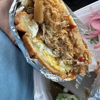 Tacos El Chingon - Torta de carnitas con chilaquiles con Huevos ..Pork meat with fried eggs on top with sauced diced tortilla chips - Street Vendors Near Me - Los Angeles, California Tacos El Chingon - Torta de carnitas con chilaquiles con Huevos ..Pork meat with fried eggs on top with sauced diced tortilla chips - Street Vendors Near Me - Los Angeles, California