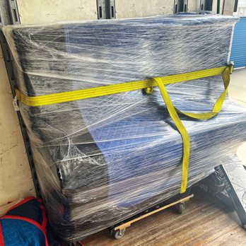 Florida Coast Moving - Fully blanketed and wrapped upright piano straps securely to the wall for transit. - Movers Near Me Florida Coast Moving - Fully blanketed and wrapped upright piano straps securely to the wall for transit. - Movers Near Me