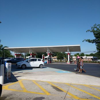 Wawa - a woman walking her dog in a parking lot - Gas Stations Near Me - Jackson, New Jersey