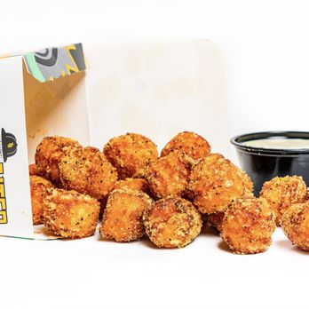 Tyga Bites - a box of tater tots and a bowl of dipping sauce - Comfort Food Near Me Tyga Bites - a box of tater tots and a bowl of dipping sauce - Comfort Food Near Me