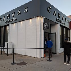 Canvas Cannabis - Outside from the sidewalk corner of Danforth & Eaton looking at the store front entrance door & people going in. Nov 2020