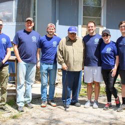 The Whole Person - A picture of a volunteer group standing with a Comsumer for planting independence.