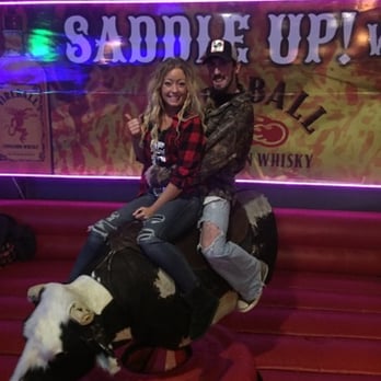 Saddle Up - a man and a woman riding a bull - Dance Clubs Near Me - Peoria, Illinois