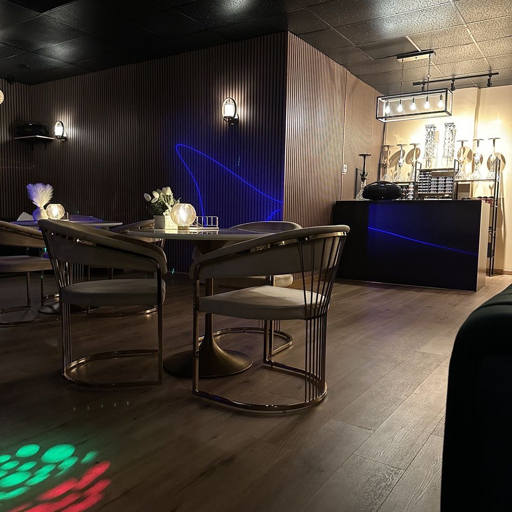 Hookah Time - a table and chairs in a dimly lit room - Hookah Bars Near Me - Sherman Oaks, California