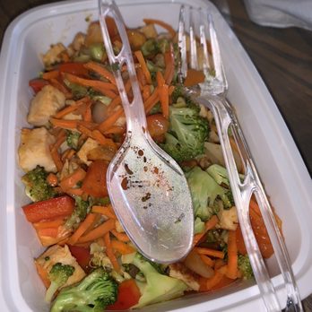 t.Loft - Primal Bowl my friends go to one she loves she said - A plastic takeout container holds a mix of cooked vegetables and chicken, with a fork, spoon, and tongs placed inside. - Juice Bars & Smoothies Near Me - Lawrence, Kansas